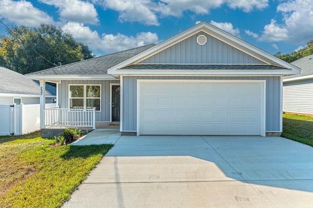 view of front of property with a front yard, a porch, and a garage