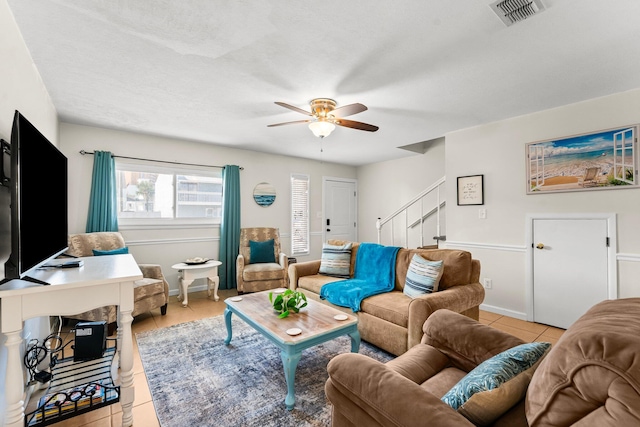 tiled living room featuring ceiling fan and a textured ceiling