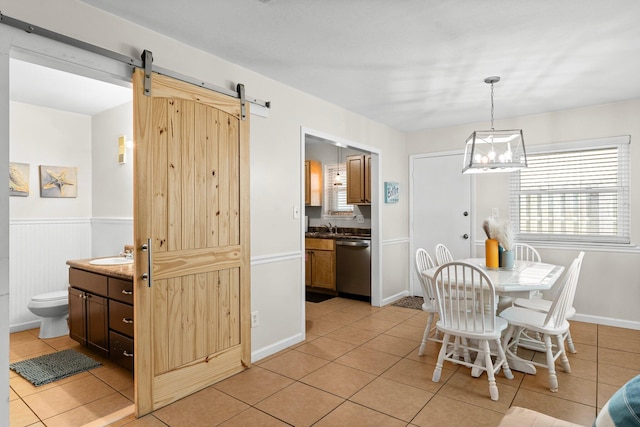 tiled dining space with a barn door and sink