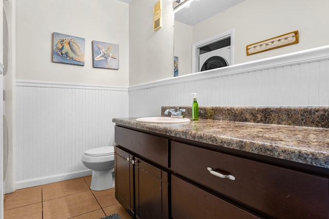 bathroom with toilet, vanity, and tile patterned floors