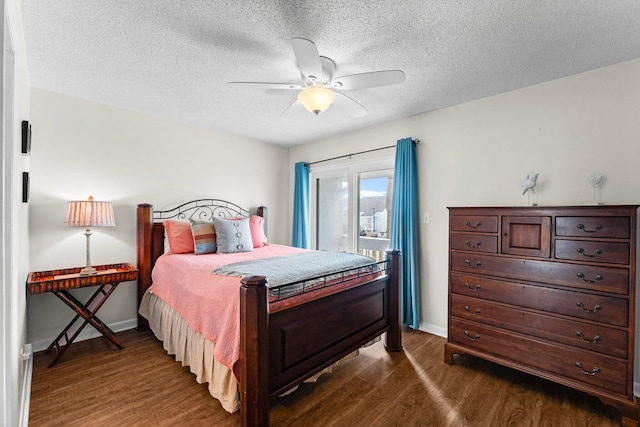 bedroom with a textured ceiling, ceiling fan, and dark wood-type flooring