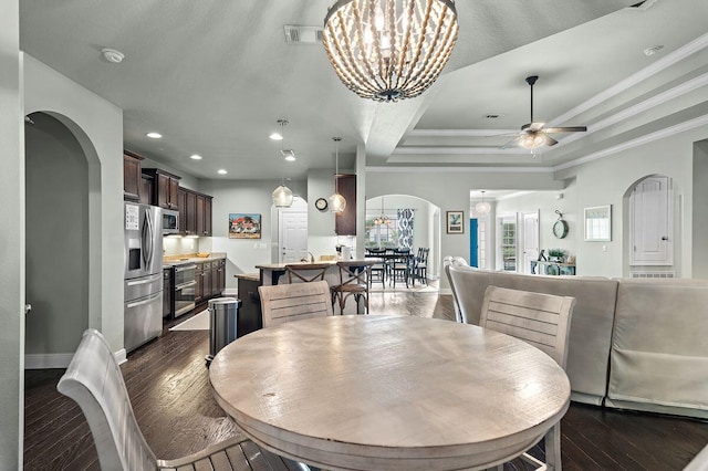 dining space with ceiling fan with notable chandelier, dark hardwood / wood-style floors, and ornamental molding