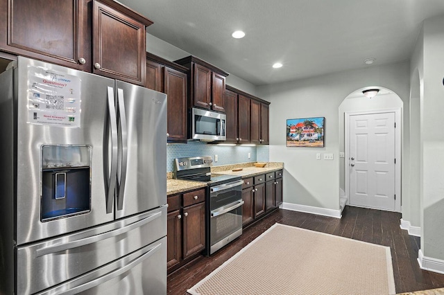 kitchen with tasteful backsplash, dark brown cabinetry, dark hardwood / wood-style floors, and appliances with stainless steel finishes