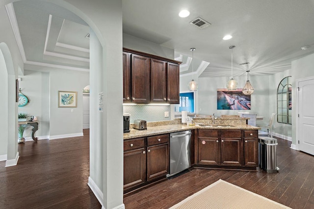 kitchen with light stone counters, hanging light fixtures, stainless steel dishwasher, and dark hardwood / wood-style floors