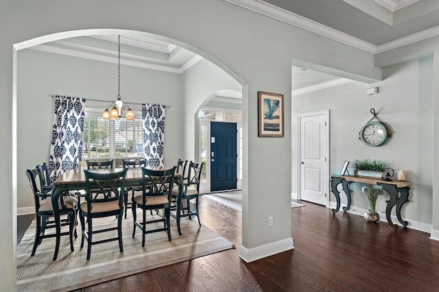 dining space with dark hardwood / wood-style flooring, an inviting chandelier, and crown molding