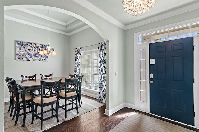 entryway with a notable chandelier, crown molding, and dark wood-type flooring