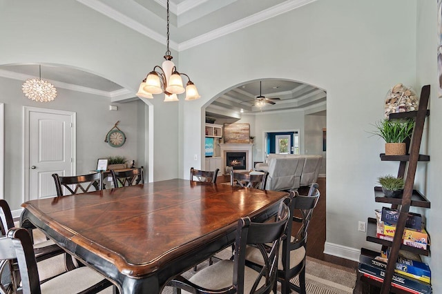 dining area featuring wood-type flooring, ceiling fan with notable chandelier, and ornamental molding