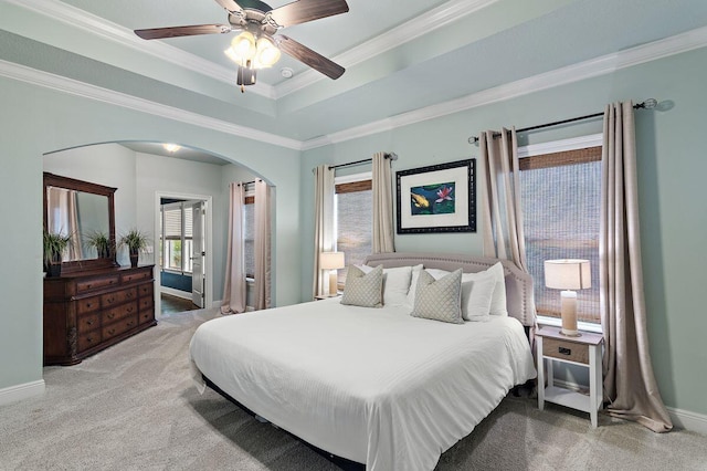 bedroom with carpet flooring, a tray ceiling, ceiling fan, and crown molding