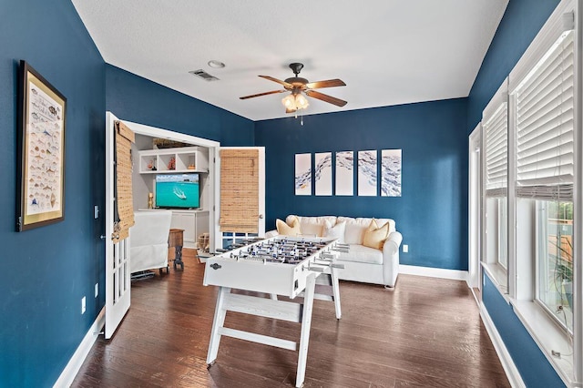 playroom featuring ceiling fan, dark hardwood / wood-style flooring, and a textured ceiling