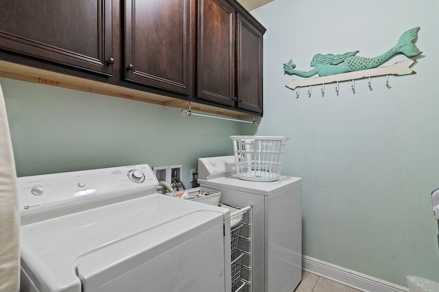 washroom featuring cabinets, separate washer and dryer, and light tile patterned floors