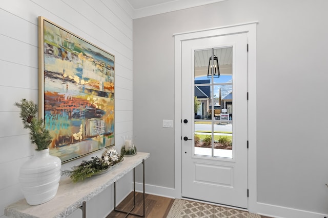 doorway to outside featuring crown molding and dark wood-type flooring