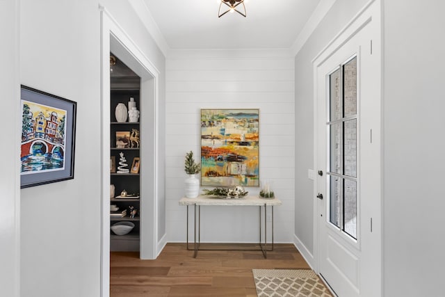 doorway with hardwood / wood-style floors and crown molding