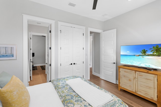 bedroom featuring wood-type flooring, a closet, and ceiling fan