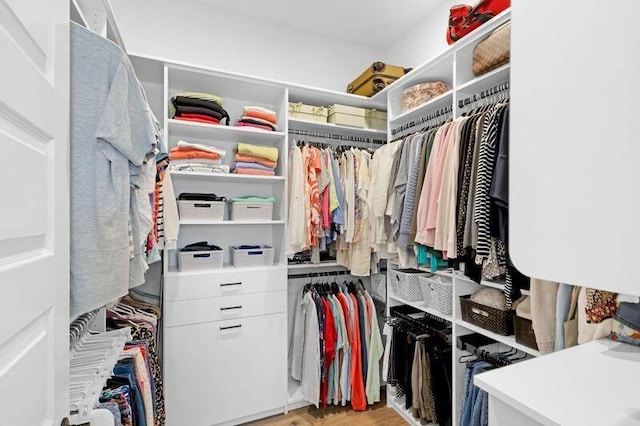 walk in closet with light hardwood / wood-style flooring