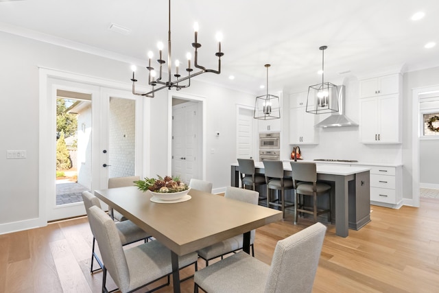 dining area with french doors, light hardwood / wood-style floors, and ornamental molding