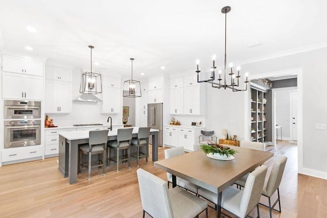 dining area featuring light wood-type flooring and ornamental molding