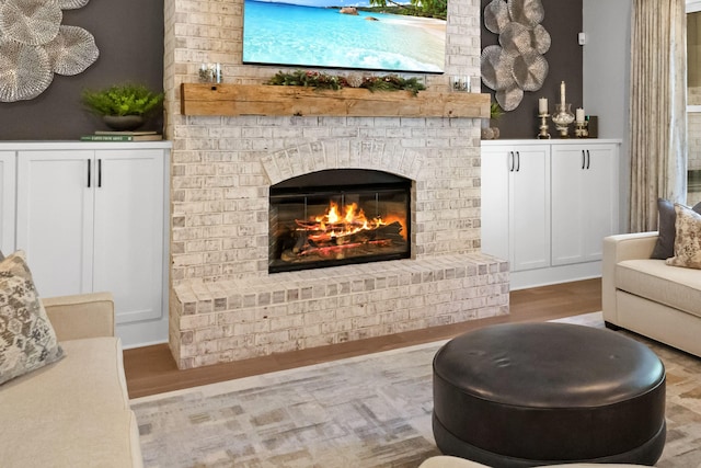 sitting room featuring hardwood / wood-style floors and a brick fireplace