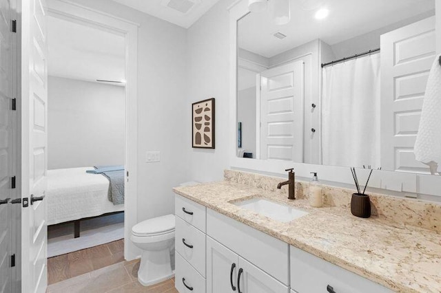 bathroom with hardwood / wood-style floors, vanity, and toilet