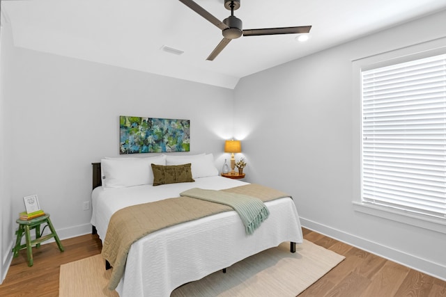 bedroom featuring ceiling fan, wood-type flooring, and lofted ceiling