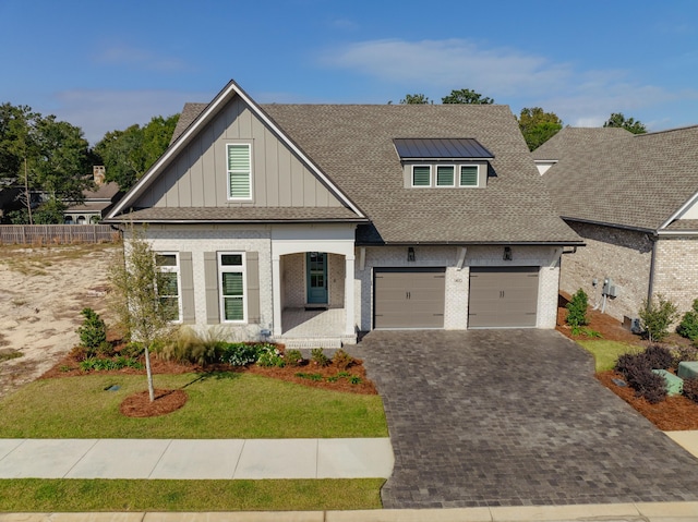 view of front of home featuring a porch, a garage, and a front yard