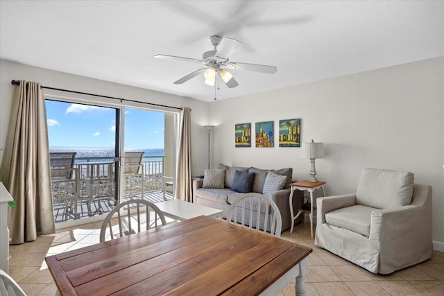 dining room featuring light tile patterned floors, a water view, and ceiling fan