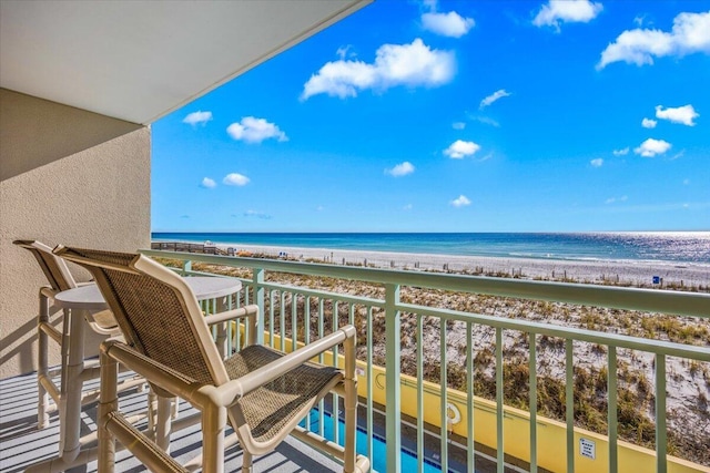 balcony featuring a water view and a view of the beach