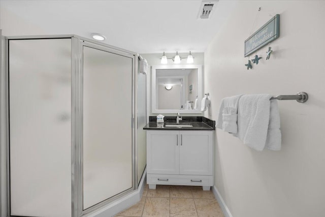 bathroom with tile patterned floors, vanity, and walk in shower