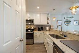 kitchen featuring appliances with stainless steel finishes, backsplash, sink, white cabinetry, and hanging light fixtures