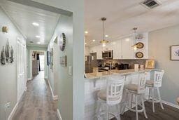 kitchen with stainless steel appliances, kitchen peninsula, wood-type flooring, a breakfast bar area, and white cabinets