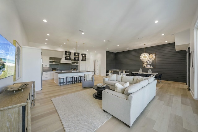 living room with light hardwood / wood-style flooring and a notable chandelier