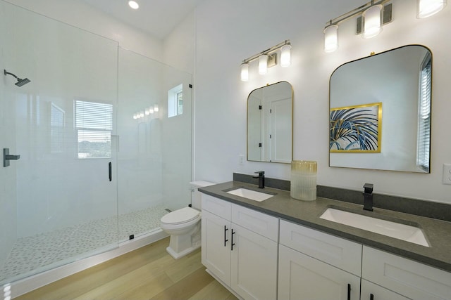 bathroom featuring an enclosed shower, vanity, wood-type flooring, and toilet