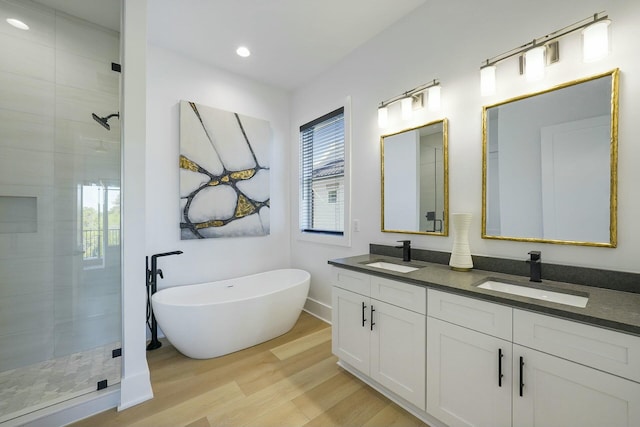 bathroom with hardwood / wood-style flooring, vanity, and separate shower and tub