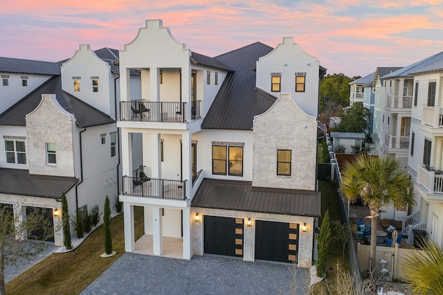 coastal inspired home featuring a garage and a balcony