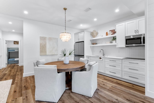 dining area with light wood-type flooring and sink