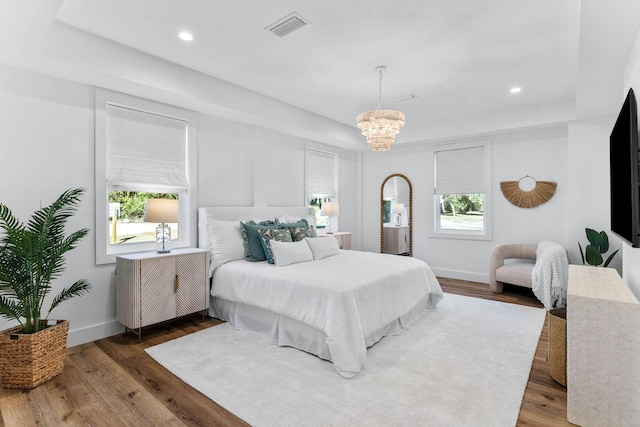 bedroom featuring dark hardwood / wood-style flooring and a notable chandelier