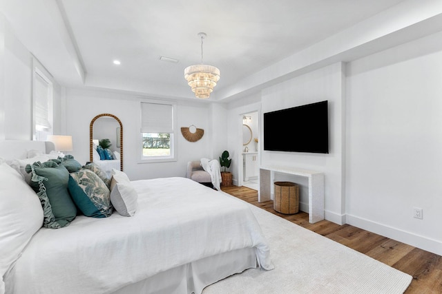 bedroom featuring hardwood / wood-style floors and an inviting chandelier