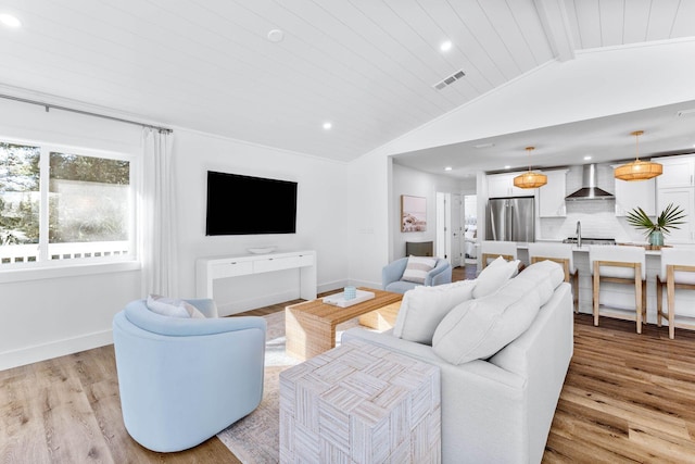 living room with light wood-type flooring and lofted ceiling with beams