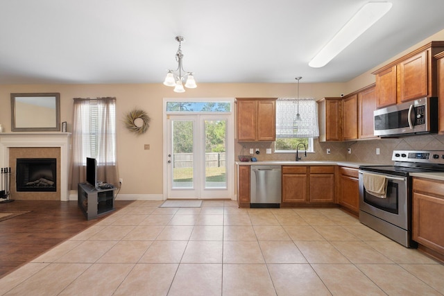 kitchen featuring light wood-type flooring, stainless steel appliances, decorative light fixtures, and an inviting chandelier