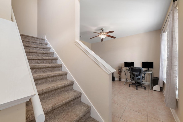 staircase featuring tile patterned flooring and ceiling fan