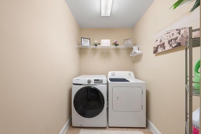 laundry room with light tile patterned flooring and washing machine and clothes dryer