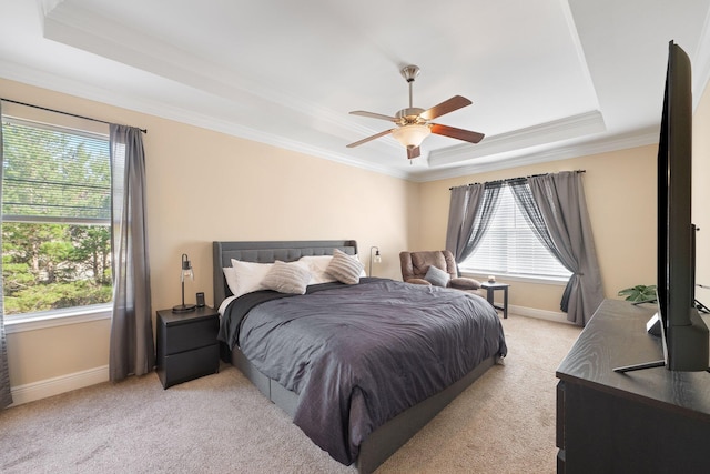 carpeted bedroom featuring a raised ceiling, multiple windows, and ceiling fan