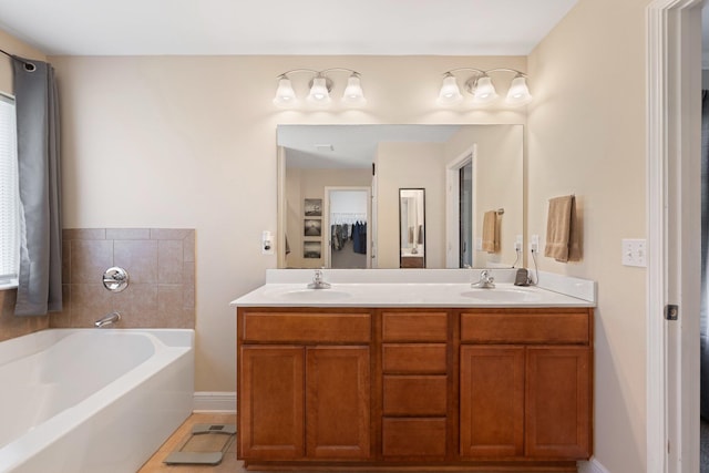 bathroom featuring tile patterned flooring, vanity, and a bath