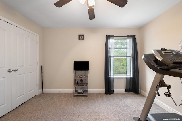 workout room featuring light carpet and ceiling fan