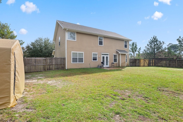 back of house with a patio area and a lawn