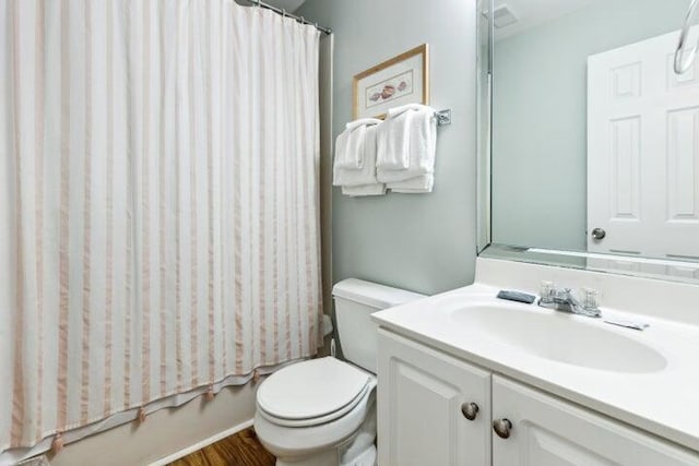 full bathroom with hardwood / wood-style floors, vanity, toilet, and shower / bath combo with shower curtain