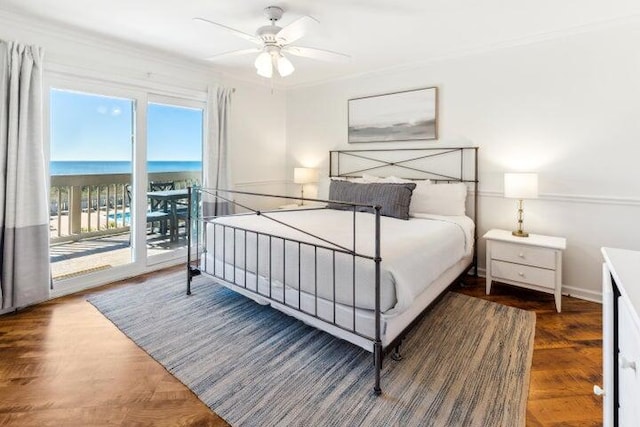 bedroom featuring access to exterior, ceiling fan, dark hardwood / wood-style floors, crown molding, and a water view