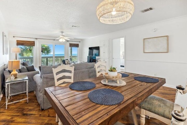 dining room featuring a textured ceiling, dark hardwood / wood-style flooring, and ceiling fan