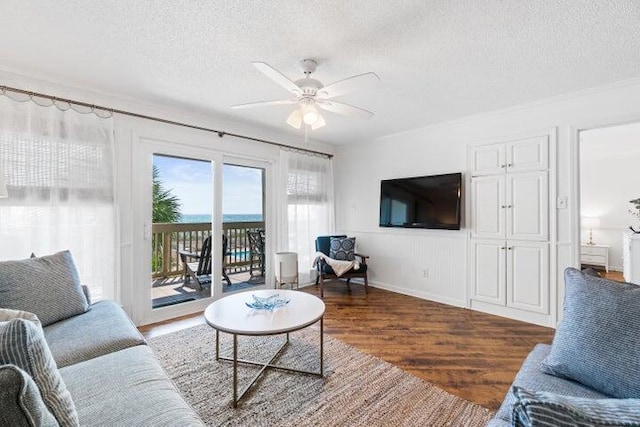 living room featuring ceiling fan, dark hardwood / wood-style flooring, and a textured ceiling