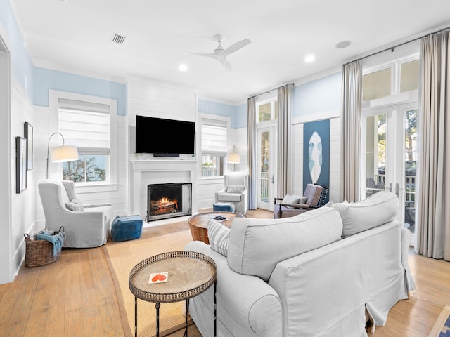 living room featuring light hardwood / wood-style flooring, plenty of natural light, and ceiling fan