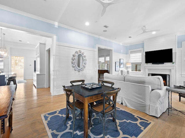 dining room with light hardwood / wood-style floors, ceiling fan, and crown molding